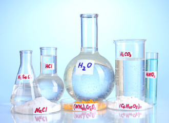 Test-tubes with various acids and chemicals on blue background