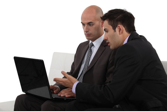 Businessmen discussing something on a laptop