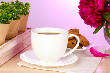 cup of coffee, cookies and flowers on table in cafe