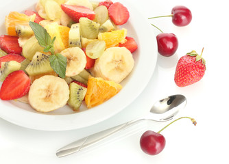 Fresh fruits salad on plate and berries isolated on white