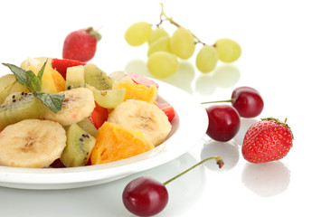 Fresh fruits salad on plate and berries isolated on white