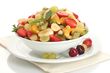 bowl with fresh fruits salad and berries isolated on white