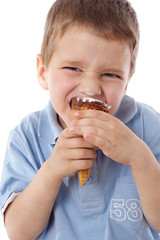 Squinting boy eating ice cream