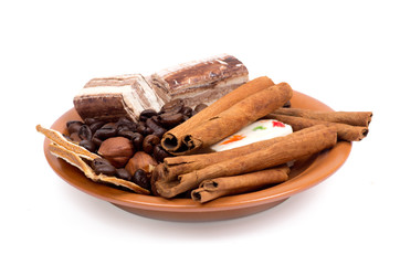 Sweets, cinnamon, nuts and coffee beans on a saucer