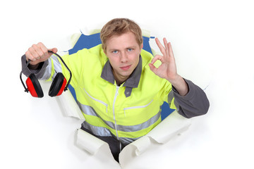 Tradesman promoting the use of earmuffs