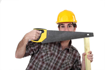 Tradesman hiding behind a saw