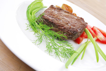 meat food : roasted fillet mignon on white plate with tomatoesan