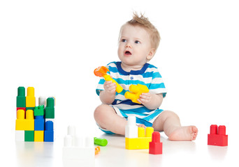 Fototapeta na wymiar cheerful child boy playing with construction set over white back