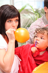 Fototapeta na wymiar Mother inflating party balloon