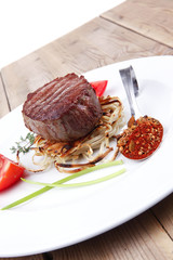 grilled beef fillet pieces on noodles with tomatoes and dry spic