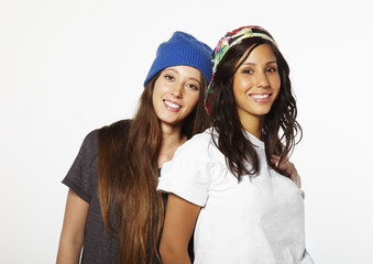 Two young  skateboarding girl friends smiling