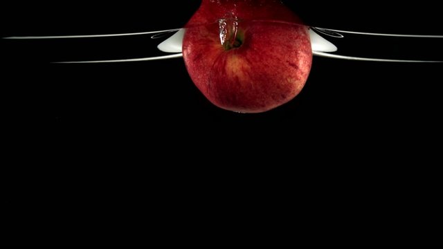Apple in water on black background, Slow Motion