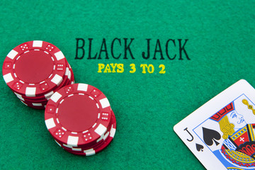 black jack with red poker chips in the background.