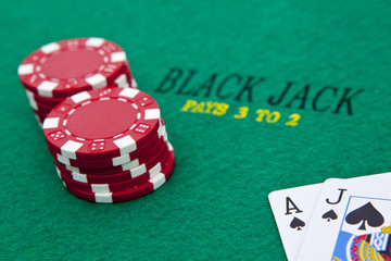 Ace of spades and black jack with red poker chips in the backgro