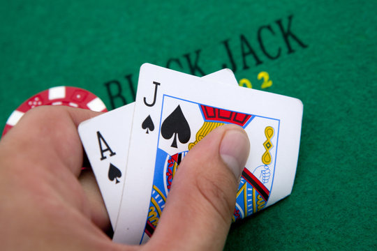 Ace of hearts and black jack with red poker chips