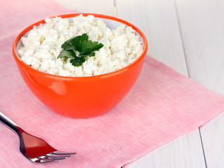 cottage cheese with parsley in orange bowl and fork