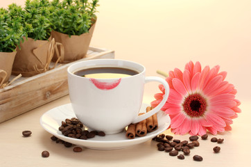 cup of coffee with lipstick mark and gerbera beans, cinnamon