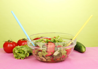 Fresh salad with tomatoes and cucumbers on green background