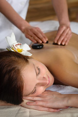 Obraz na płótnie Canvas Hot stone massage woman enjoy spa treatment