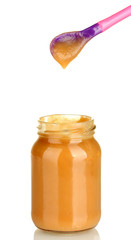 Jar with baby food and spoon on white background close-up