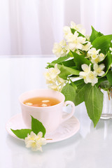 Cup of tasty jasmine tea and flowers