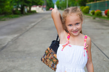 child goes on the road with a bag in his hands