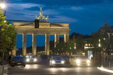 Brandenburg Gate lit with car pedestrian traffic at night on Un