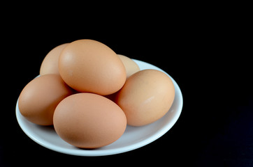 eggs on plate on black background
