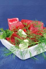 fresh beef meat slices in a white  over blue