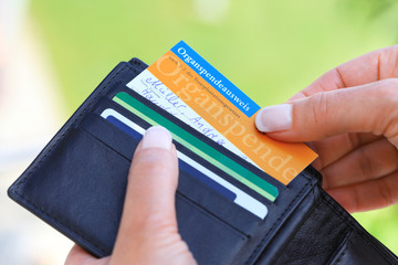 Frau zieht Organspendeausweis aus Portemonnaie