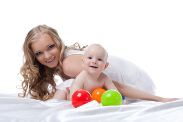 Smiling mother and baby in bed