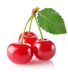 three sweet juicy cherry with green leaf isolated on white