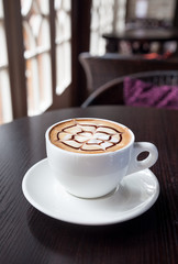 mocha coffee drink on a wood table by the window