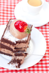 beautiful cake with strawberry and tea on plaid fabric