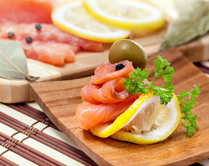 Salmon snack on the wooden plate, studio shot