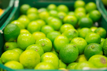Bunch of green limes in boxes in supermarket