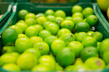 Bunch of green limes in boxes in supermarket