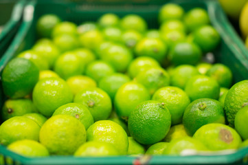 Bunch of green limes in boxes in supermarket