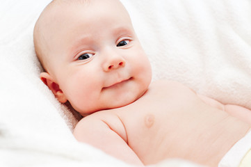 boy lying on white towel