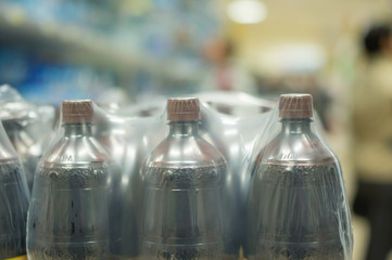 Bottles with fresh water on shelves in supermarket