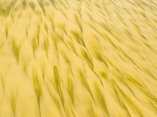 Golden sand pattern created by surf on beach