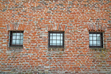 brick wall with iron lattice window of an ancient prison