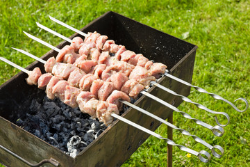 meat pieces cooking on a skewer