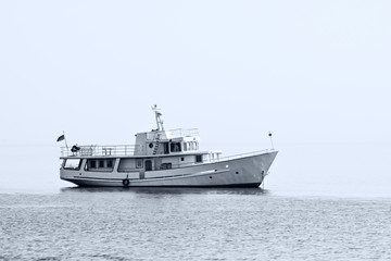 Fototapeta na wymiar A small ship lying at anchor in the fog