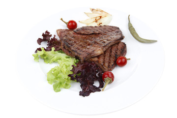 two grilled steak with chili and red peppers