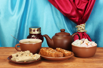 Teapot with cup and saucers with oriental sweets - sherbet,
