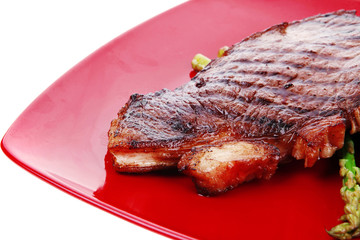 beef fillet with asparagus served on red dish