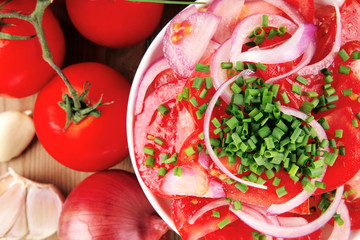tomato salad in white bowl with bundle of chives