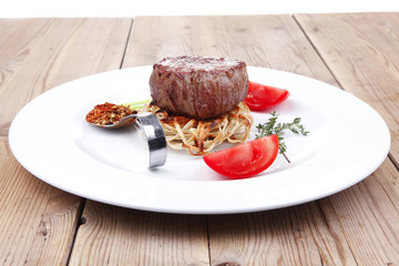 grilled beef fillet pieces on noodles with tomatoes and dry spic