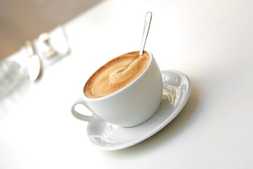 small white cup of cappuccino